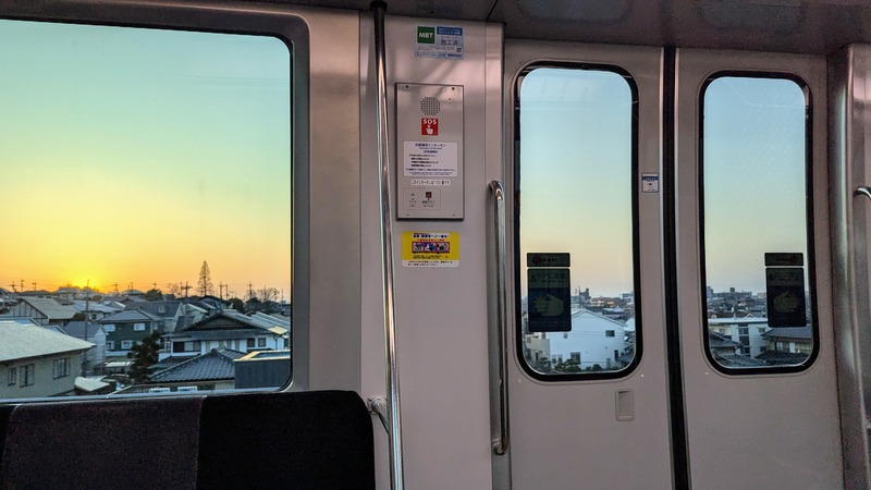 A view of houses out the window of a Japanese train